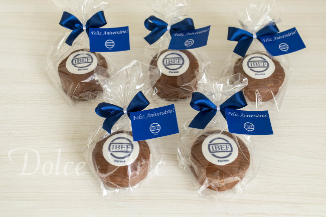 Pães de Mel decorados com a logo da empresa, embalados em celofane com fita e tag personalizada para evento corporativo
