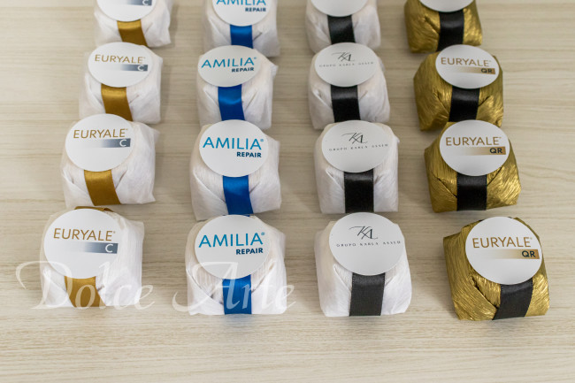 Bem-Sucedidos com fita de cetim e tag redonda com a logo da empresa para evento corporativo