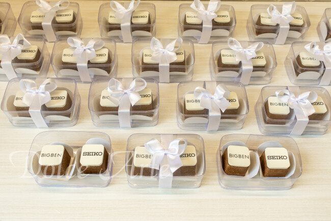 Caixas de Acetato corporativas com 2 bombons decorados com a logo, com fita e tag personalizada