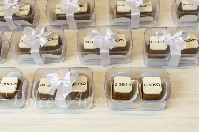 Caixas de Acetato corporativas com 2 bombons decorados com a logo, com fita e tag personalizada