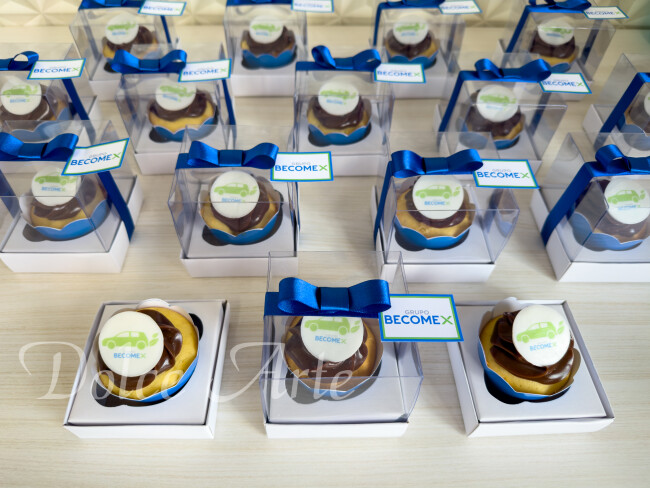 Cupcakes decorados com a logo em caixa de acetato, fita e tag personalizada para evento corporativo