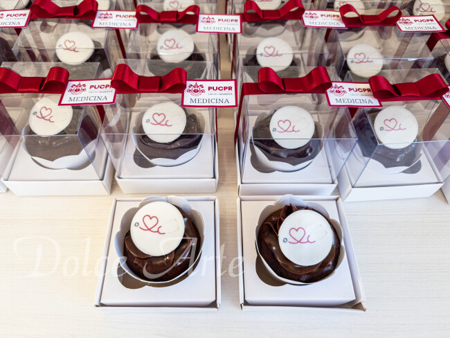 Cupcakes decorados com a logo em caixa de acetato, fita e tag personalizada para evento corporativo